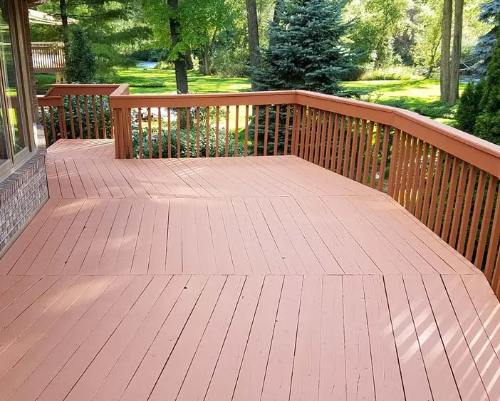 An after image of a deck that has been stained with a red opaque stain
