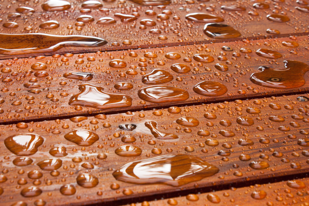 A red-brown tinted deck with drops of rain on it